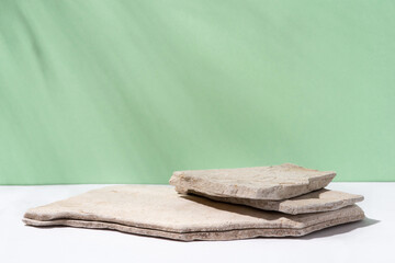 Background for cosmetic products of natural green color. Stone podium on a green background. Front...