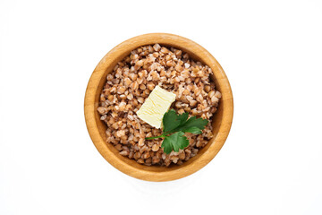 Buckwheat porridge in bamboo bowl with parsley leaf and butter isolated in white background. Gluten free ancient grain for healthy diet. Top view. Copy space.