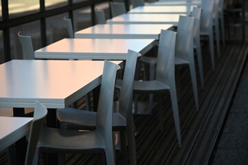 Obraz premium Row of empty white restaurant terrace tables