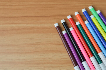 Top view of pen colors on wooden table with copy space
