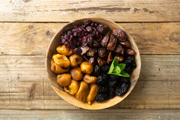 Dried fruits on wooden plate, healthy snack, sweet fruits, rustic style