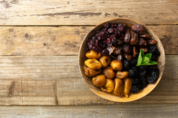 Dried fruits on wooden plate, healthy snack, sweet fruits, rustic style