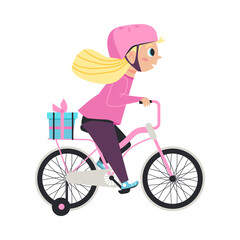 Little cute girl in safety helmet riding on kids bicycle with gift on trunk.