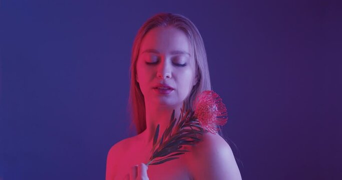 Beautiful young woman with protea flower on color background