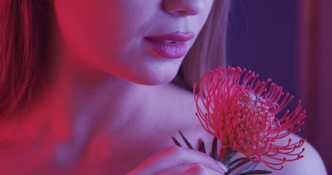 Beautiful young woman with protea flower, closeup
