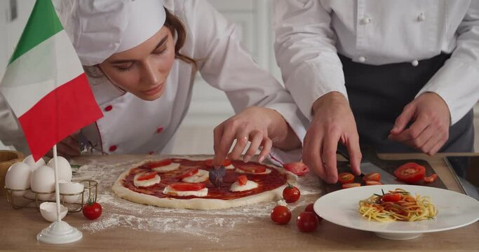 Italian chefs cooking traditional pizza in kitchen