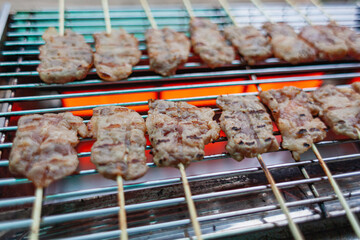 Grilled pork with many sticks on the stove.