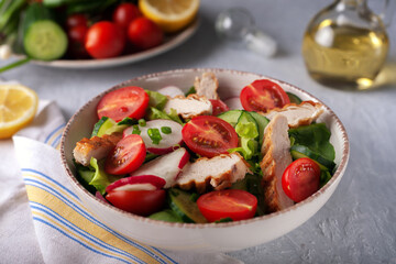Grilled chicken breast, fillet and fresh vegetable salad of lettuce, spinach, cucumber and tomato