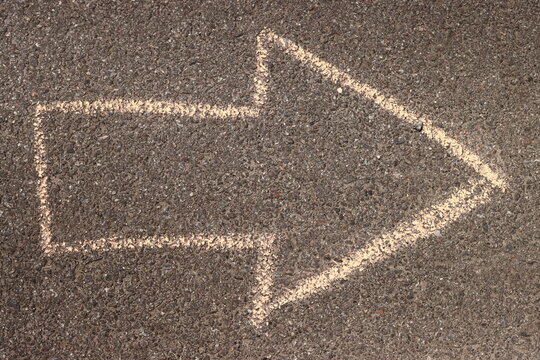 arrow drawn in chalk on the asphalt