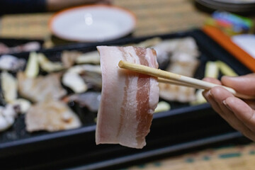 Raw sliced pork belly chopsticks