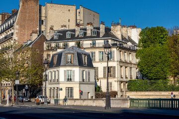 Fototapeta na wymiar Paris, France - April 13, 2021: View of ile saint-louis and quai Henri IV, typical facades and quays in Paris
