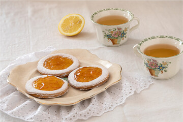 Homemade shortcrust pastry jam cookies with cups of tea.