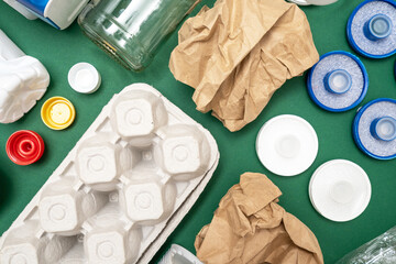 Different objects, domestic garbage arranged on green background