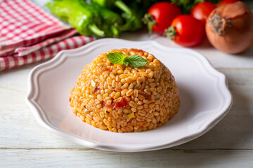 Traditional turkish bulgur pilaf with tomato sause in plate (Turkish name; meyhane pilavi)