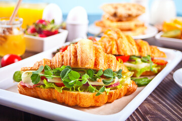 Croissant sandwiches with ham, cheese greens. Breakfast concept.