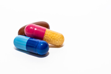 Close-up colorful powder soft capsules pill isolated on white. blue pink yellow brown medicine supplement