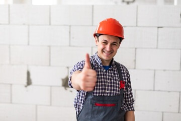 Worker man hand giving thumb up over blurred construction site. Successful concept