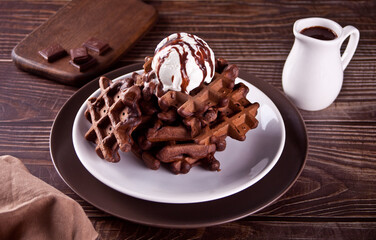 Homemade chocolate waffles with ice cream decorated chocolate syrup.