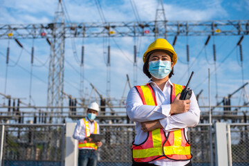 Female electrical engineers working at power substations, Electrician with radio communication in...