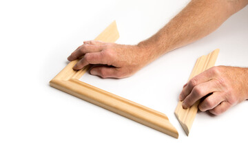 worker holding angle cut wood to make a picture frame isolated on white