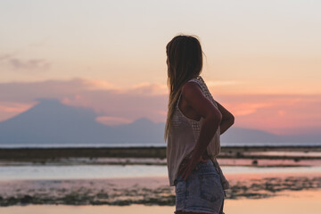 Young blonde girl on Gili Trawangan beach in Lombik, Indonesia at sunset time