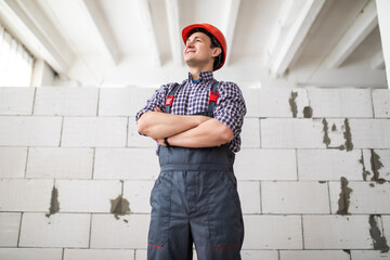 Portrait Of Male Builder Wearing Hard Hat Working In New Build Property