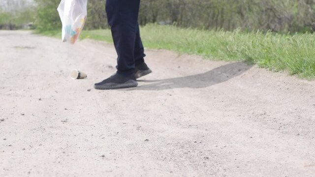 Plogging on trail in the forest. Close up picking up plastic trash outdoor