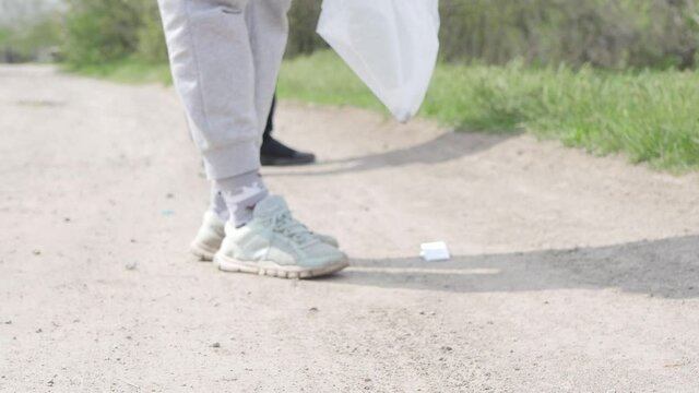 Plogging on trail in the forest. Close up couple  picking up plastic trash outdoor
