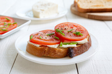 Whole grain bread with goat cheese and fresh tomatoes. Healthy and tasty breakfast.
