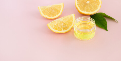 Lemon slices and cosmetic lemon oil on a pink background. Close up,space for text