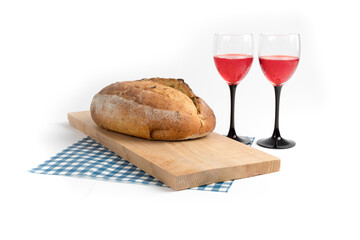 artisanal bread buns on wooden board with wine glasses isolated on white
