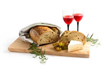 artisanal bread buns on wooden board with wine glasses isolated on white
