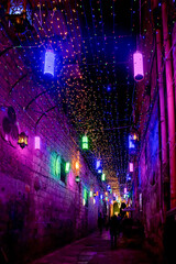 evening or night Street of the old city of Jerusalem decorated with bright multi-colored bulbs for Ramadan in the Arab quarter of Jerusalem's Old City.
