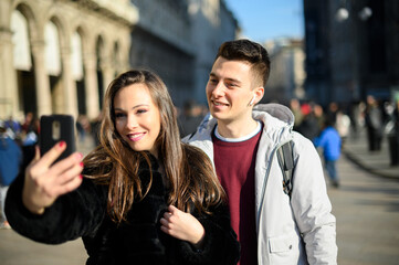 Couple of tourists taking selfies in Milan