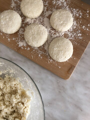 Blind cheesecakes of cottage cheese on a wooden cottage and cottage cheese in a cup. selectiv focus