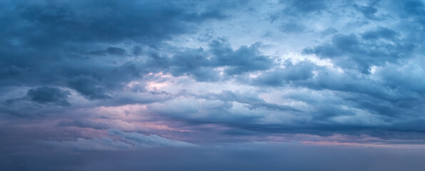 Dramatic overcast sky at evening panoramic shot. Scenic blue gray clouds before the storm. Scenic cloudscape before the rain. Blue hour stormy cloudscape. Dark thunderstorm sky wide image. - obrazy, fototapety, plakaty