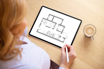 Woman working on home plan on tablet computer