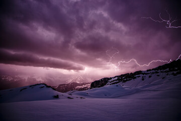 Gewitter Sturm mit Blitzen in Schnee bedeckten Bergen in den Alpen beim Wandern