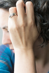 Obraz premium 40 year old woman touching graying curly hair; female embracing natural hair color going dye free