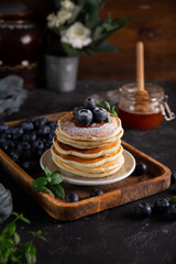 Homemade pancakes with blueberries and powdered sugar on the table close-up