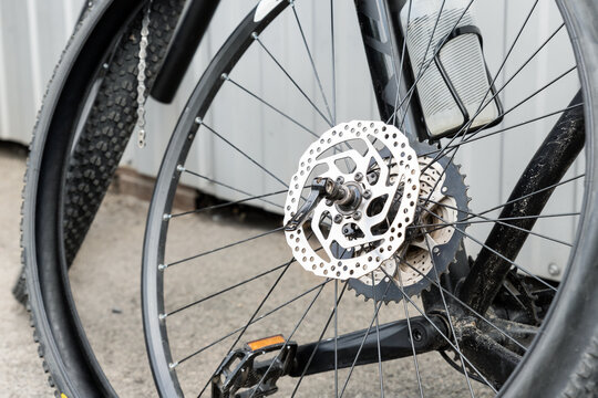 Close-up Detail Disassembled Black Carbon Fiber Bicycle With Removed Wheel And Tyre After Puncture Or Accident At Repair Workshop Fix Station Outdoors. Parts Of Sport Light-weight Bike On City Street