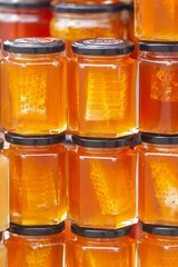 Fototapeta na wymiar Fresh honey in glass jars with pieces of honeycomb, food concept.