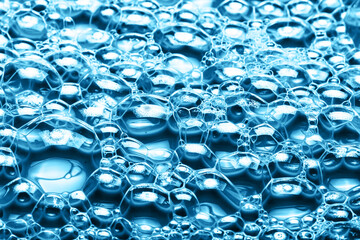 Water foam texture. Blue bubble spa background. Foam structure backdrop. Shapoo soap washing pattern. Shiny air bubbles. Closeup washing suds. Detergent, water and oil reaction.