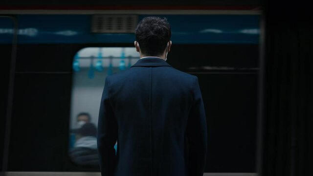 Young businessman waiting for train underground