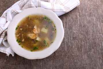 Mushroom soup with chicken and barley. Decorated with greenery. On an old wooden background. Top view.