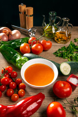 bol de gazpacho en una cocina con tomate, pimiento, cebolla pepino y ajo - 433098676