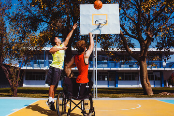 latin young man using wheelchair and playing basketball with a friend in Mexico, disability concept