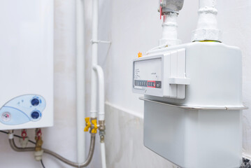 Home gas meter against the background of an autonomous heating boiler in the kitchen of the apartment