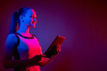 Digital future. Cyber technology. Modern lifestyle. Happy smiling neon light woman with tablet in...