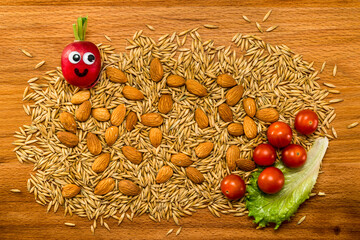 Mr. Radish is smiling and looking at the corns and almonds with cherry tomatoes on wooden table. Close-up view from above